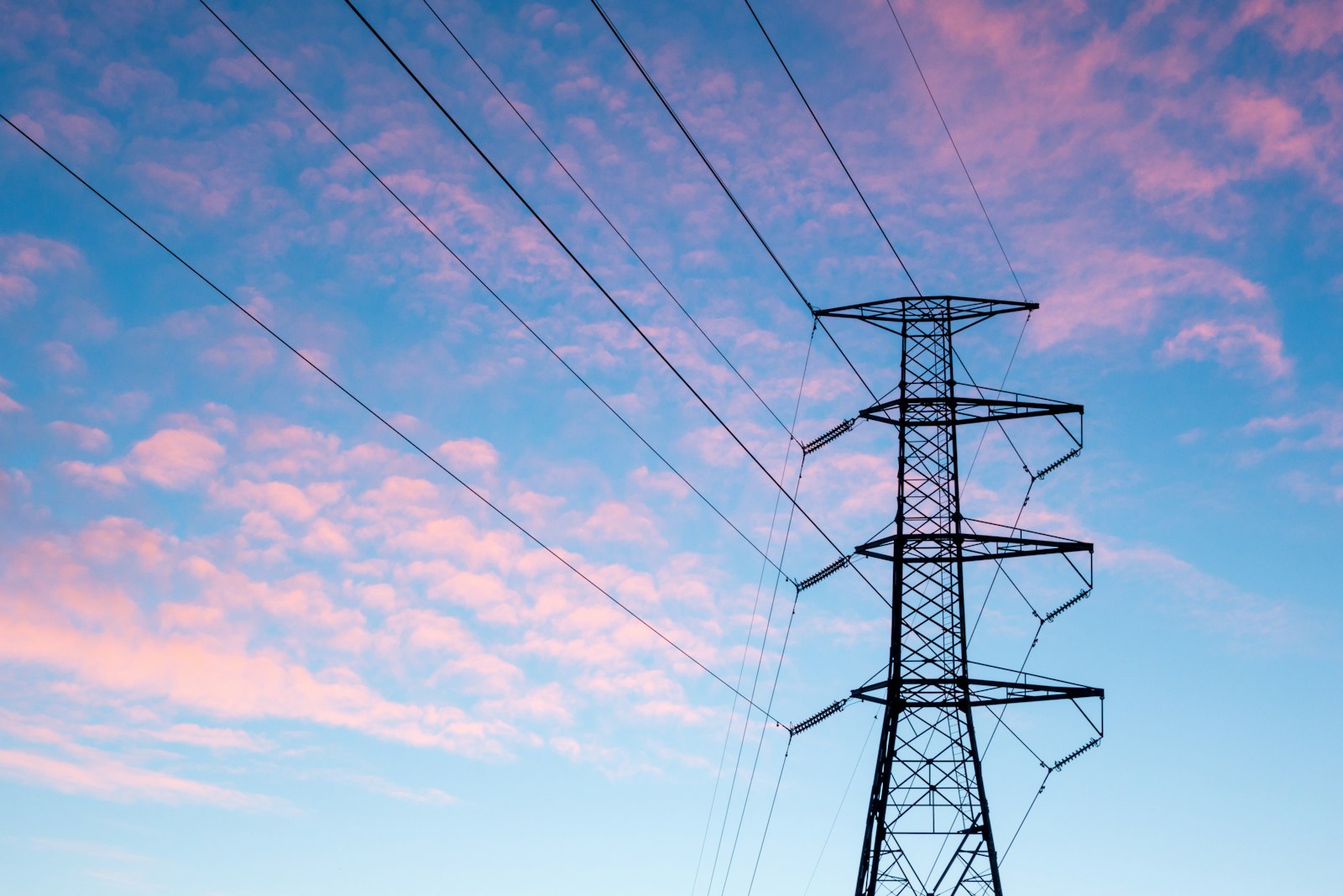 An electric transmission tower at sunset
