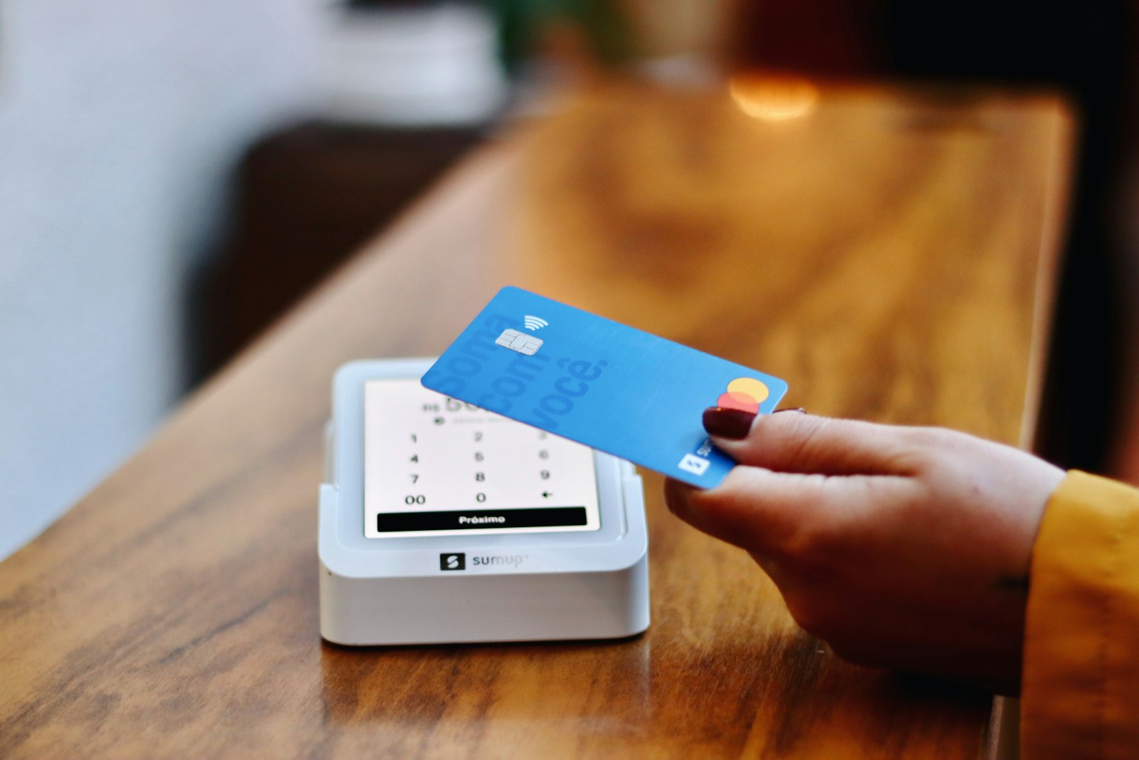 A credit card held in front of a payment terminal